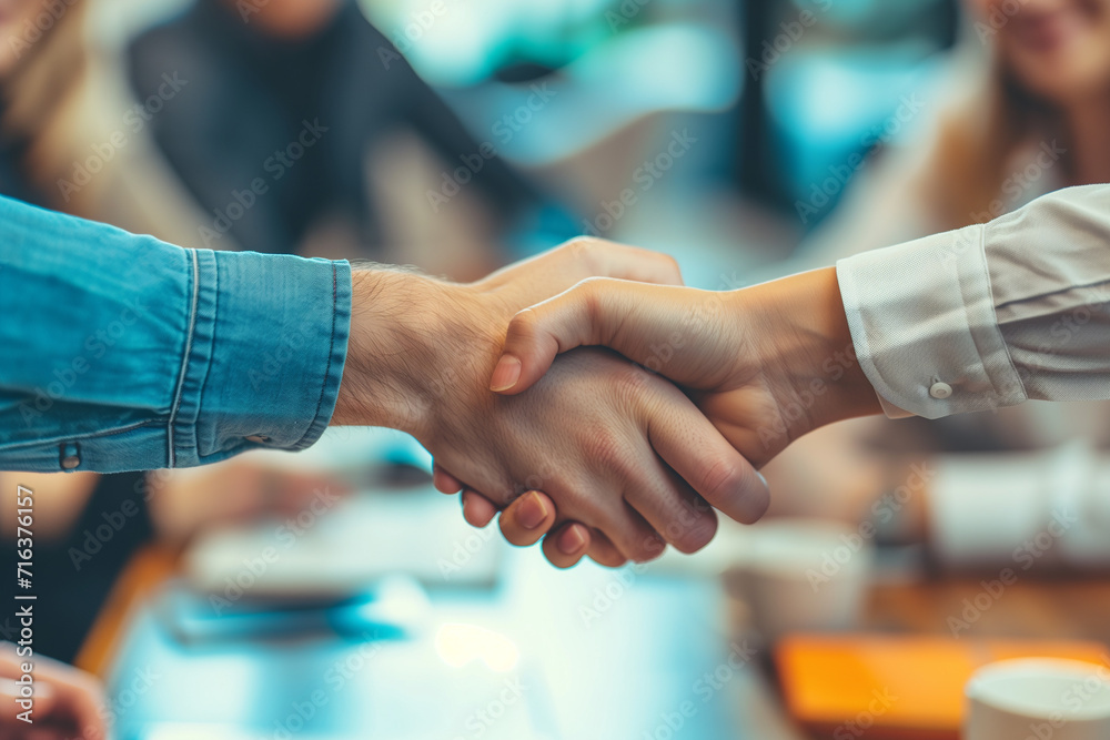 Wall mural close-up of hands in a firm handshake after a triumphant partnership in the office, a powerful image