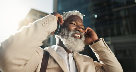 Happy, dancing and senior businessman with headphones in the city walking and listening to music. Smile, happy and elderly African male person streaming playlist, song or radio commuting in town. - obrazy, fototapety, plakaty
