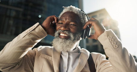 Happy, dancing and senior businessman with headphones in the city walking and listening to music....