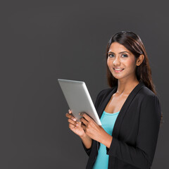 Happy Indian Woman using a digital tablet.
