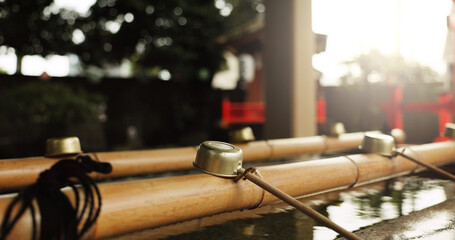 Shinto temple, closeup and fountain with water in container for faith, clean or washing hands for...