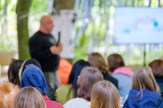 An instructor holding a class in a natural environment, with attentive participants listening.