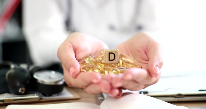 Doctor nutritionist holding vitamin D tablet closeup. Treatment with biological food supplements and vitamins