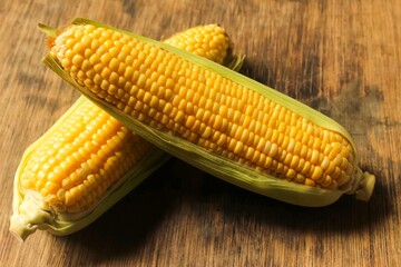 two raw corns on a wooden table