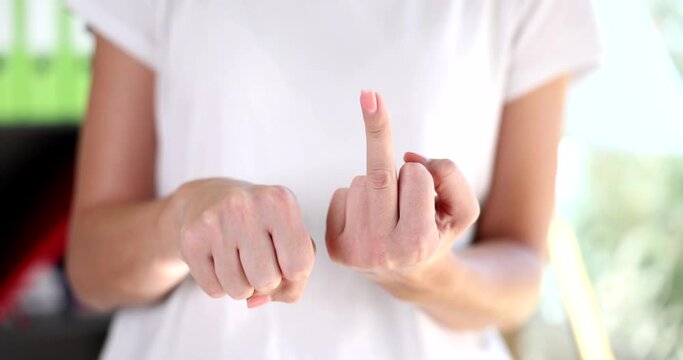 Woman slowly raises middle finger as sign of resentment and contempt hand gesture. Indecent angry gesture and emotions