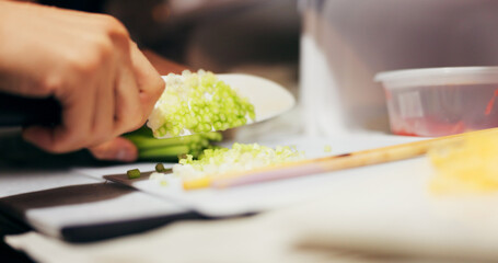 Hands, cut and vegetables on table with knife, japanese food and chef by dinner for healthy diet. Person, cooking and ingredients for vegetarian lunch for nutrition and board by meal prep in kitchen