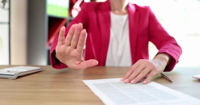 Businesswoman with contract document with open hand making stop sign. Refusal of contract and protective gesture