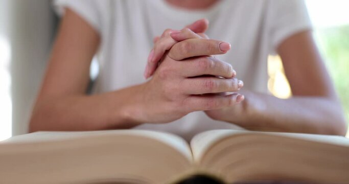 Christian joined hands in prayer for blessings of Jesus sitting on bible. Concept of reading prayer and faith