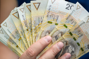 Wachlarz polskich pieniędzy w dłoni, płacić banknotami 200 pln