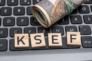 KSEF napis na klawiaturze komputera, krajowy system e-faktur napis leży na laptopie obok polskich pieniędzy 