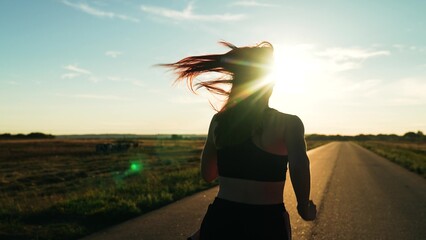 silhouette sports girl running along road sunset, marathon runner sport running. triathlete,...