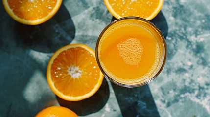 Abwaschbare Fototapete From above glass of fresh made orange juice © Mishab