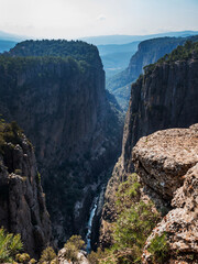 View of the Tazy Canyon gorge from the Turkish Mountain. A turquoise river flows below. Bird's eye view. No people. Vertical