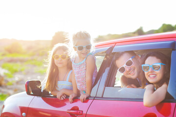 Portrait of a smiling family with two children at beach in the car