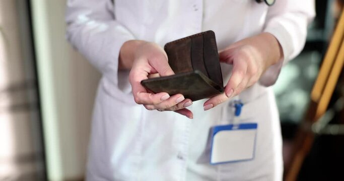 Doctor considers money dollars put into wallet. Bribery and corruption in the healthcare sector