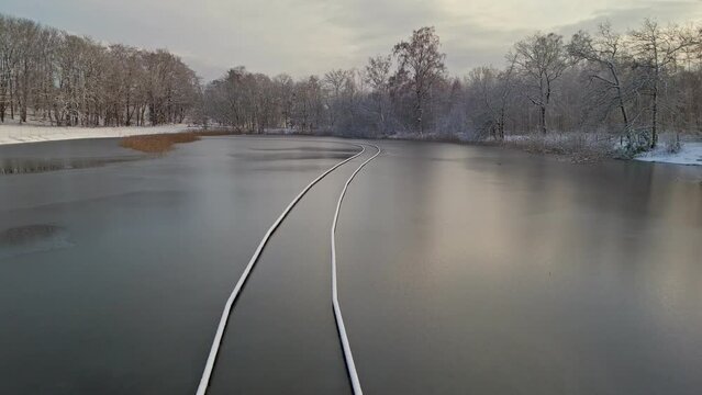 Sunken Boardwalk with snow in winter landscape and frozen lake