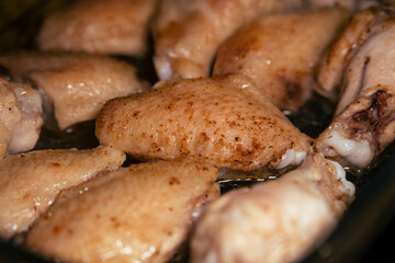 Baked chicken wings in spices close-up. Cooking healthy food at home