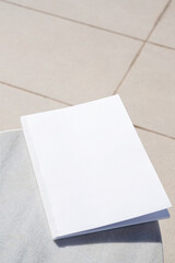 blank magazine for mockup design on marble table by the swimming pool