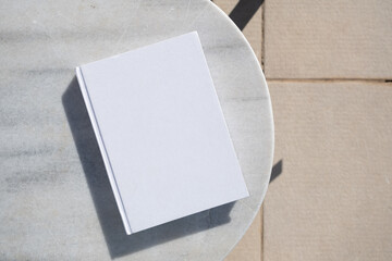 blank book for mockup design on marble table by the swimming pool