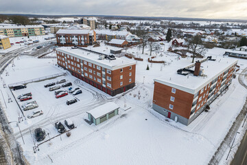 Aerial view of residential area in Sweden with low-rise and private buildings during winter. Snowy weather, snowfall in a little European village, town, city.