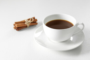 Turkish coffee. Freshly brewed beverage and cinnamon on white table, closeup