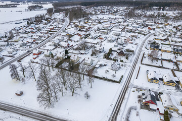 Aerial view of residential area in Sweden with low-rise and private buildings during winter. Snowy weather, snowfall in a little European village, town, city.