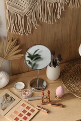 Mirror and makeup products on wooden dressing table