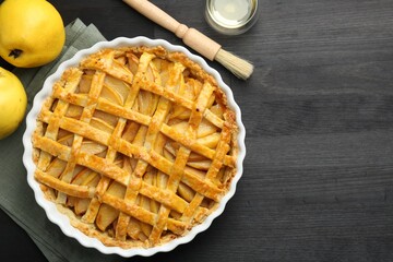 Tasty homemade quince pie and fresh fruits on black wooden table, flat lay. Space for text
