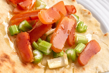Primo piano di deliziosa insalata di bottarga di muggine a fette con sedano, pane carasau e un filo di olio di oliva, antipasto sardo di mare, cibo italiano 