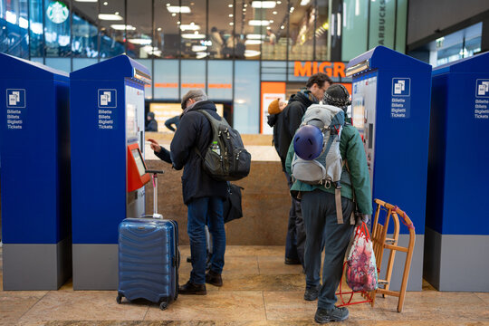Basel Switzerland 22.12.2023, Caucasian passengers standing at the ticket vending machines which written on the side: "Billette", "Billets", and "Biglietti", signifying "Tickets" in French and Italian