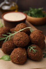 Delicious falafel balls and arugula on table