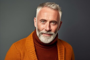 Portrait of a handsome mature man in an orange sweater. Men's beauty, fashion