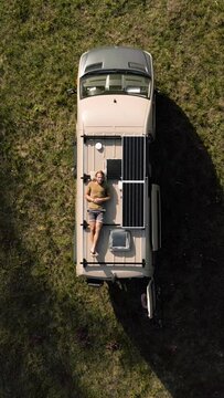 Aerial View of a Man Relaxing on the Roof of a Camper Van
