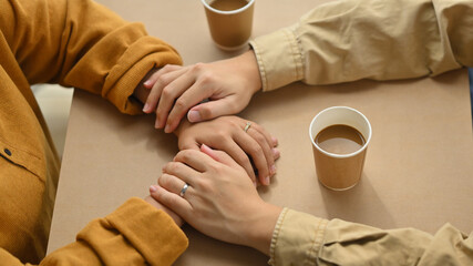 Married couple holding hands on date in cafe. Love, relationship, togetherness and lifestyle concept