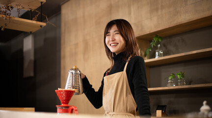 キッチンに立ってコーヒーを淹れる笑顔の女性