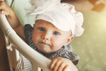 Adorable baby with beauty eyes wear blue shirt and stylish hat looking at camera in white round...