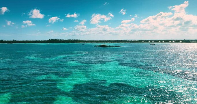 Aerial panorama view of reefs and swimming pools in caribbean sea, tropical islands in the water and horizon with wild beach shore with palm trees jungle 4k drone video