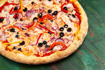 Pizza with cheese, tomatoes, peppers, onions and olives. Close-up.