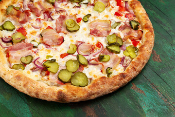 Pizza with bacon, cucumber, onion, cheese. Close-up.