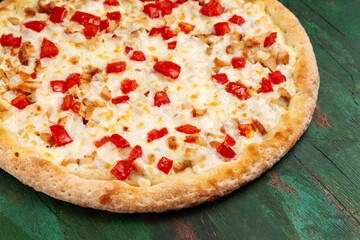 Pizza with chicken, tomato, cheese. Close-up.