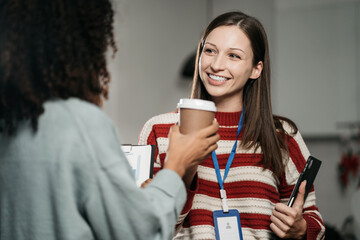 colleagues clinking cups of coffee in office.