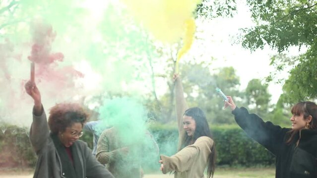 group of young people dancing with smoke cans having a good time and enjoying free time and friendship in a music festival