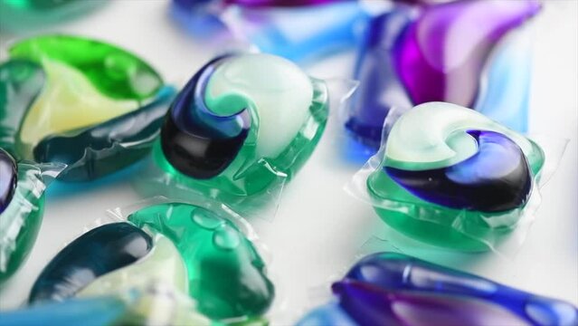 Washing capsules, colorful laundry pods. Colorful Soluble capsules with laundry gel detergent and dishwasher soap. Pile of washing pod capsules rotating. Detergent tablets. Top View 