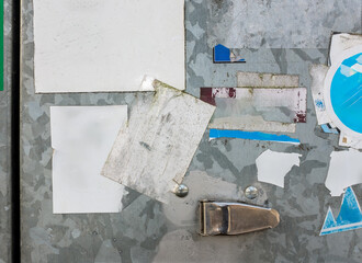 many different sticker scraps or remains on solid stone concrete wall.
