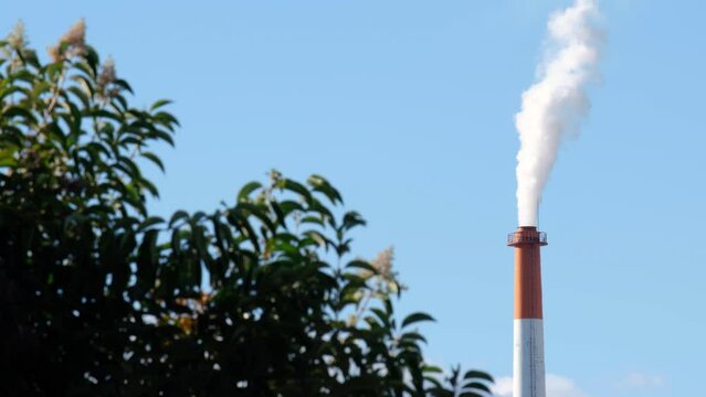 The chimney of a power plant with cloud sky.