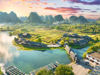 Aerial view of Shangri-la Gardens at sunset, boats in the river, rice fields and karst mountains in the background, Yangshuo, Guilin, Guangxi Province, China