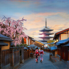 Scenic cityscape of Yasaka pagoda sunset in Kyoto with a young Japanese woman in a traditional...