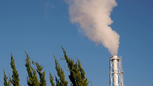 The chimney of a power plant with cloud sky.	