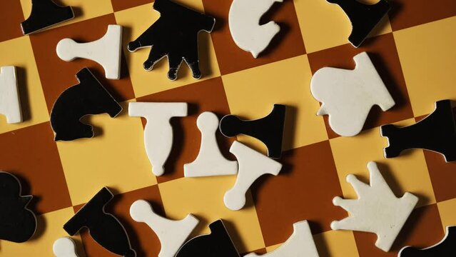 Demonstration chess puzzles on chessboard, top view. Chess pieces are randomly arranged, close-up. 4K video, rotating. Concept of chaos or misunderstanding of game process.