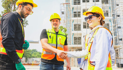 Teamwork handshake cooperation of architects and male and female workers multiethnicon on the apartment construction site condominium building for success in the project teamwork and achieving goals.
